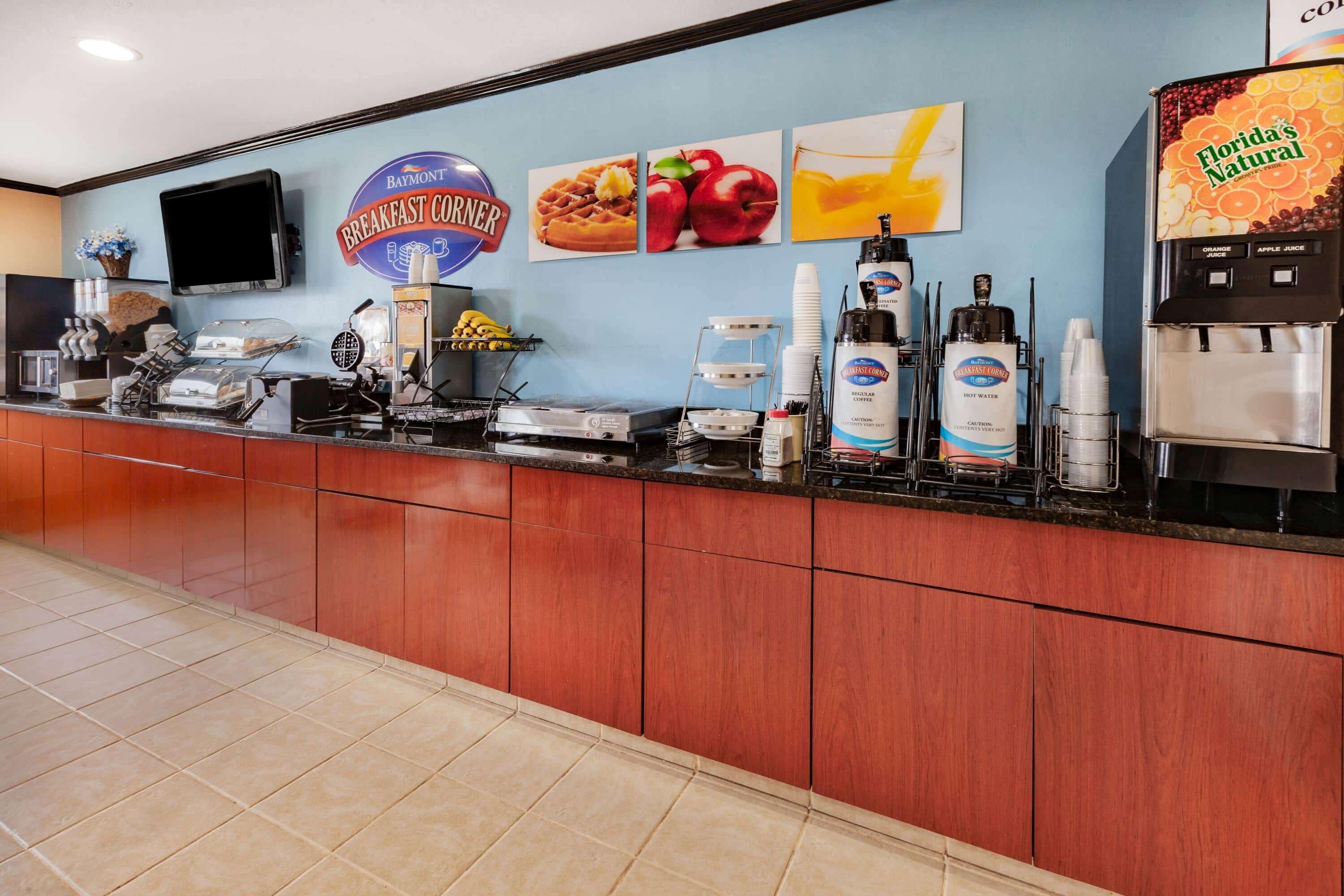 A breakfast counter with a coffee machine, hot water dispenser, and juice dispenser.