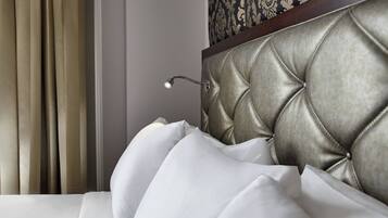 A close-up of a bed with a tufted headboard and white pillows.