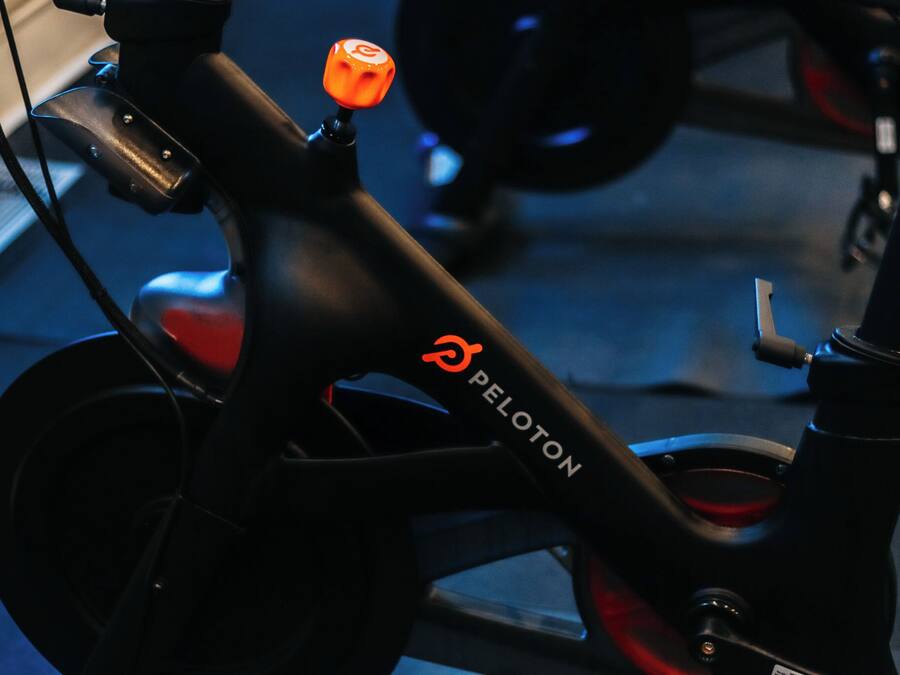 A close-up of a bicycle with the brand name 'PELOTON' on the frame.