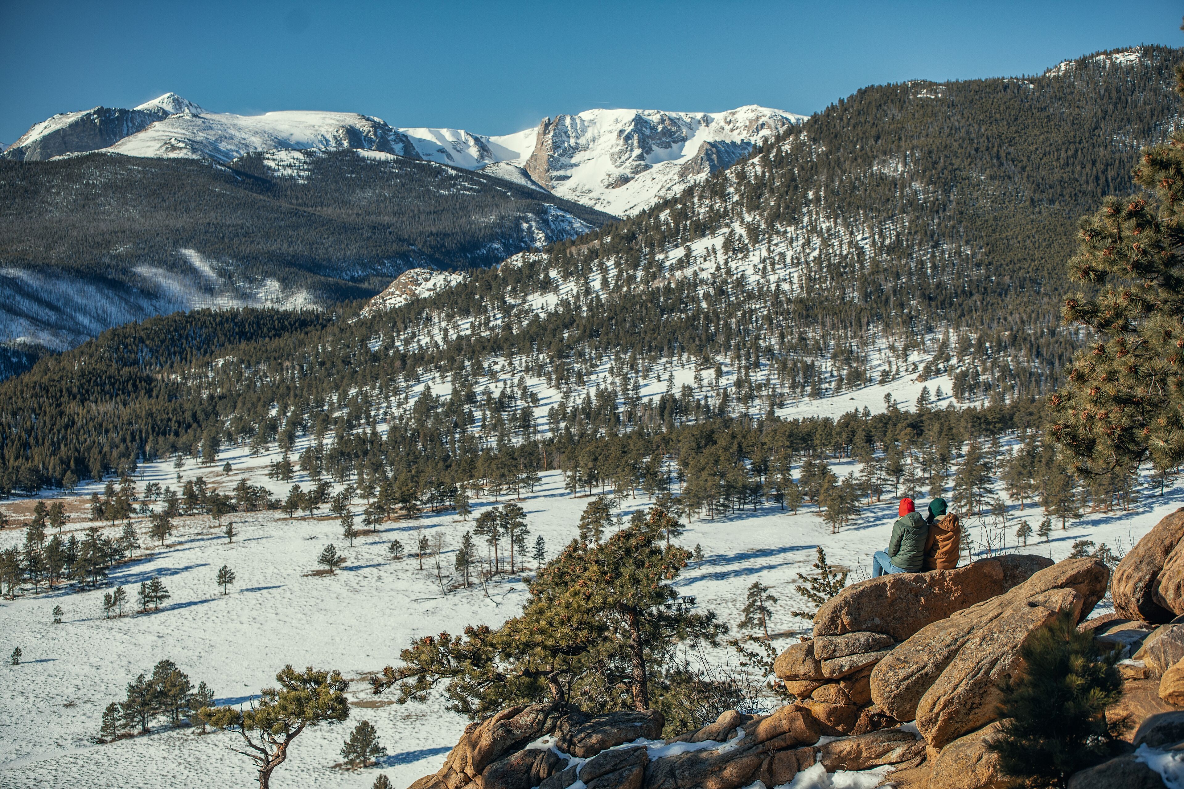 A mountainous landscape with snow-covered peaks and a clear sky.