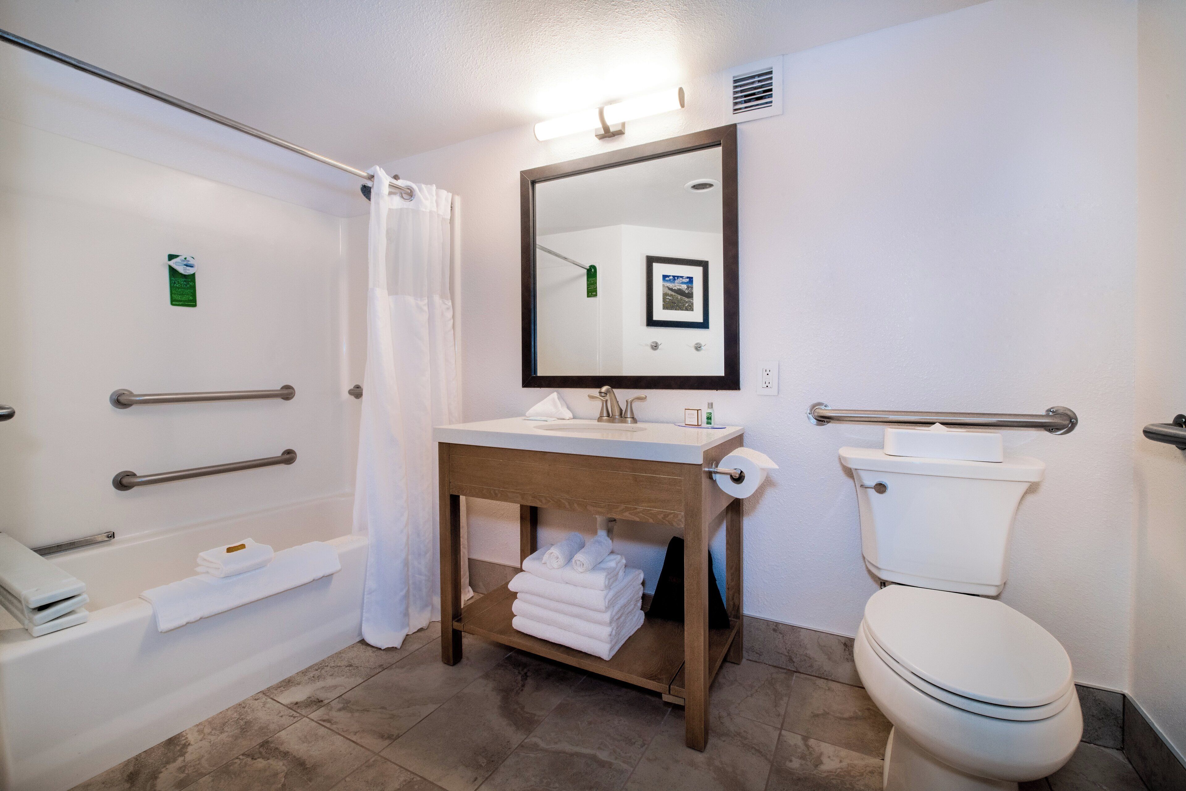 Un baño con bañera, lavabo, inodoro y espejo.