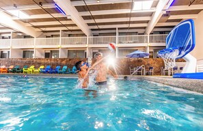 An indoor swimming pool with a basketball hoop, lounge chairs, and a stone wall. - Holiday Inn Estes Park by IHG (Estes Park)