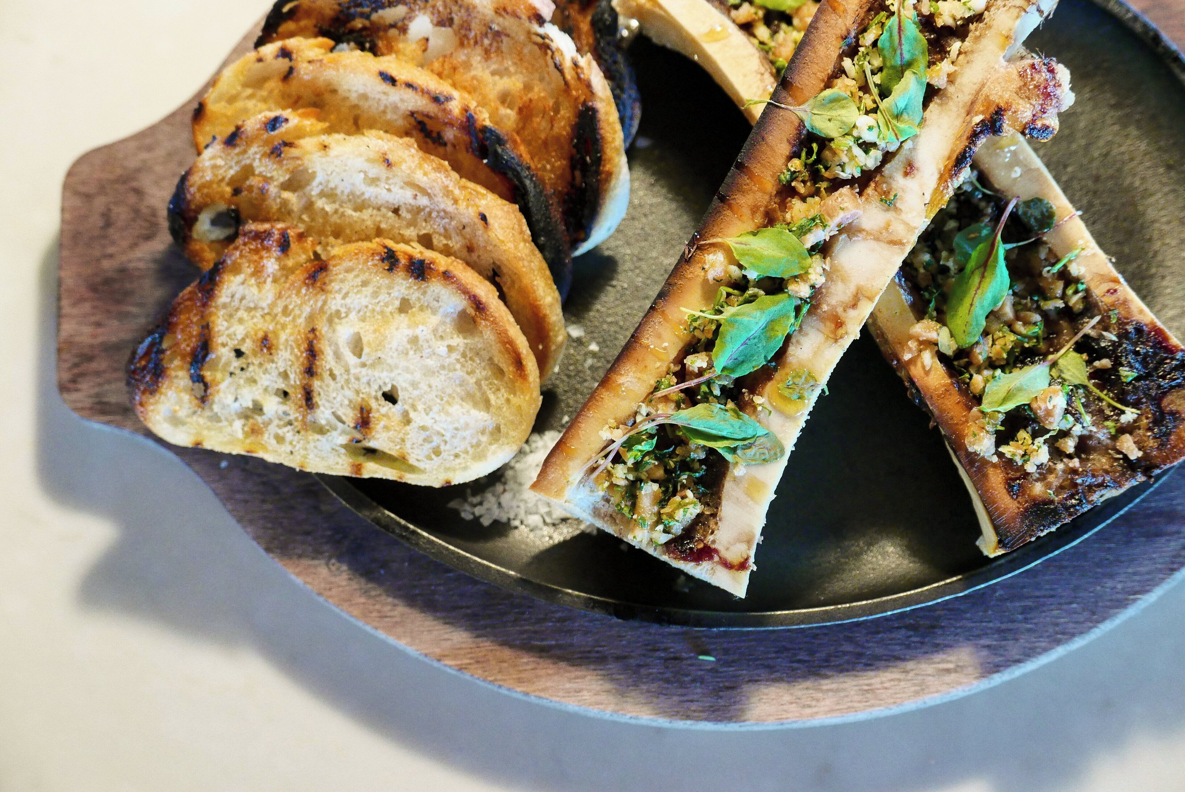 A plate with grilled bread and a sandwich.