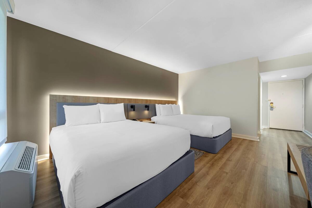 Ett modernt hotellrum med en stor säng, sängbord och en inbyggd värmare.