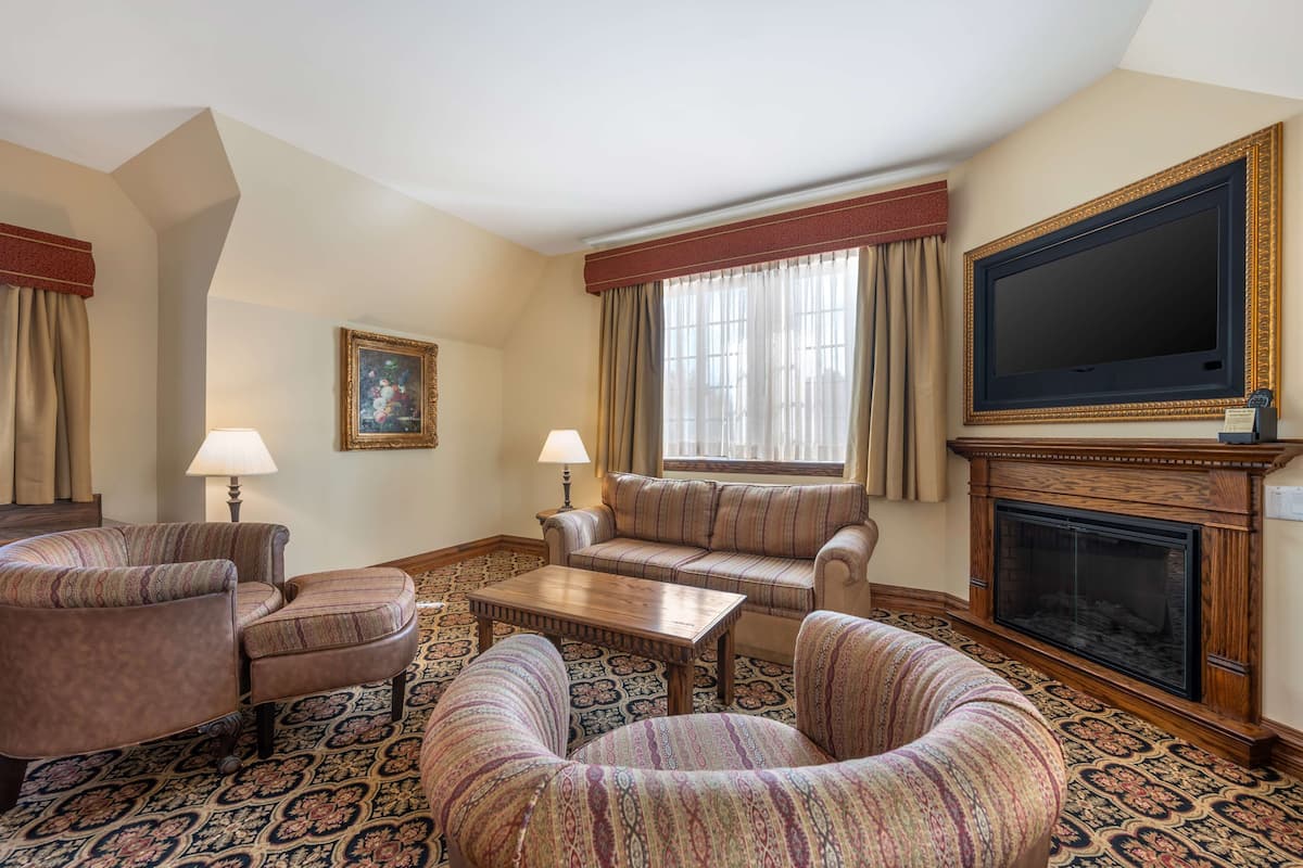 A living room with a fireplace, two sofas, a coffee table, and a television.