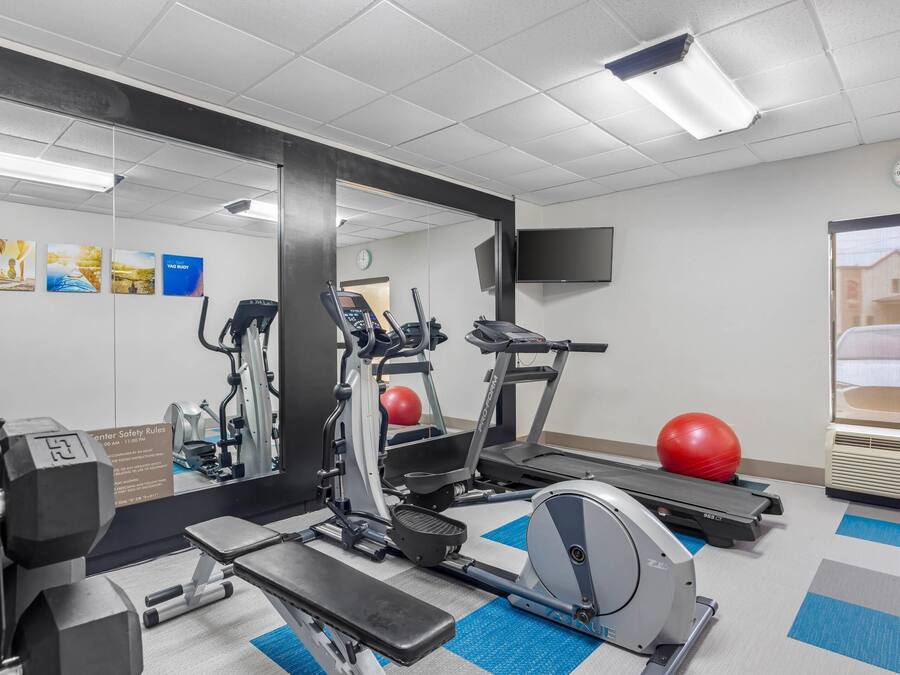 Un gimnasio con cintas de correr, elípticas y pesas sueltas.