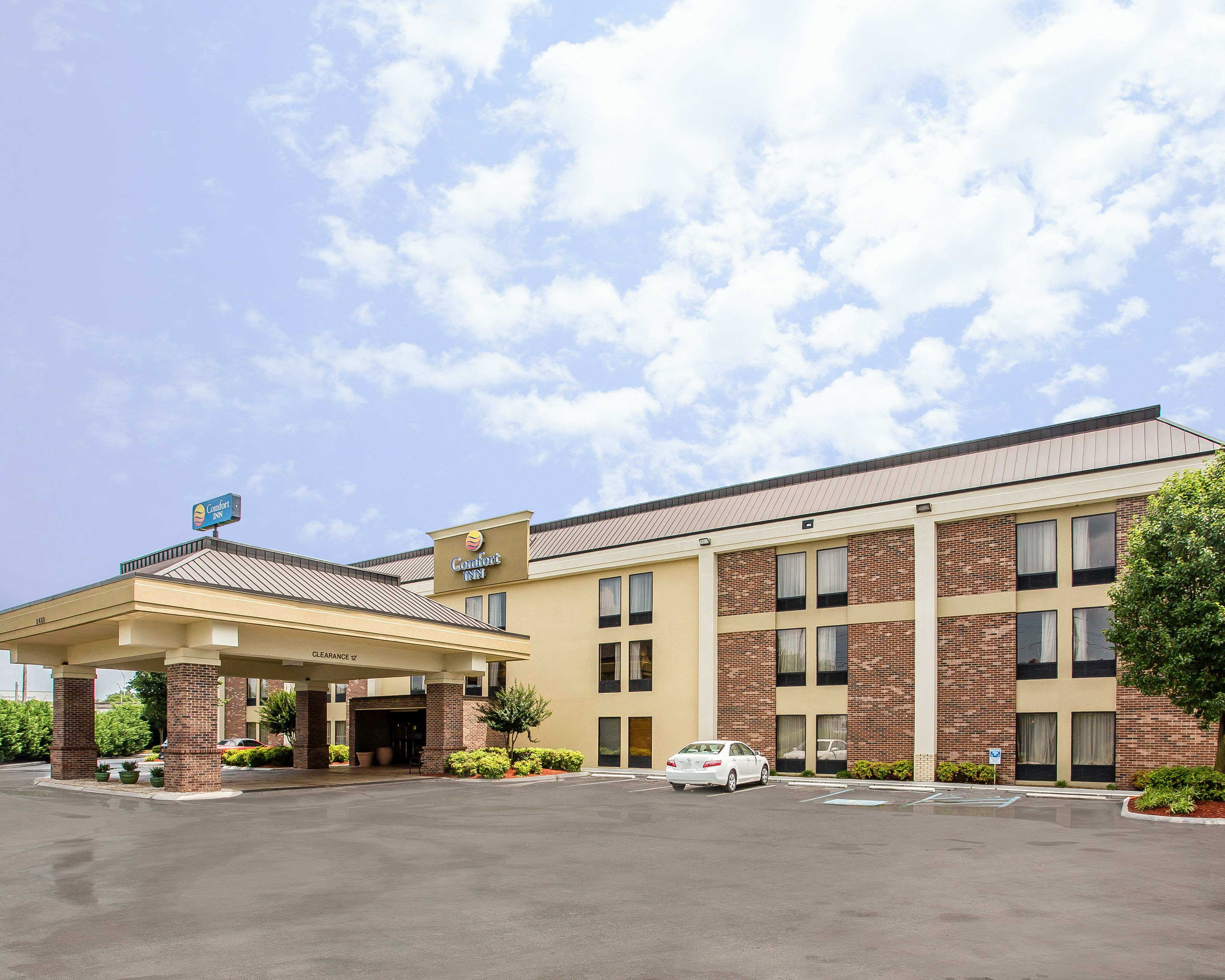 A Comfort Inn hotel with a covered parking area, brick facade, and multiple windows.