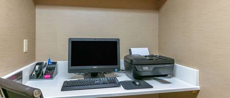 A small office space with a desk, computer, printer, keyboard, mouse, and chair.