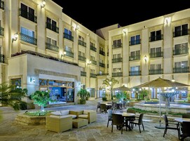 Un patio de hotel con asientos al aire libre, una fuente y un restaurante.