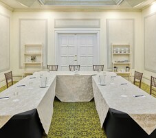 Un salón de conferencias con una larga mesa, sillas y una puerta al fondo.