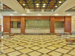 A lobby with a patterned floor, a reception desk, and a ceiling with decorative plates. - Fiesta Americana Aguascalientes (Aguascalientes)