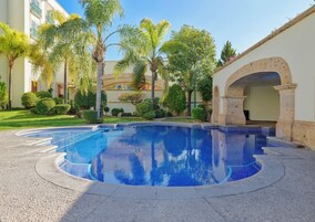 Una piscina al aire libre, camas de piscina gratis, sombrillas