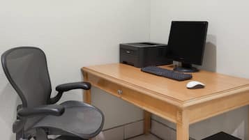 A wooden desk with a computer, keyboard, and mouse.