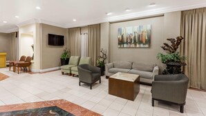 Una sala de estar moderna con un sofá, sillones, una mesa de centro y plantas decorativas.