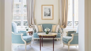 A room with a sofa, two armchairs, a small table with a vase, and a framed picture on the wall. - Le Bristol Paris - Oetker Hotels (Paris)