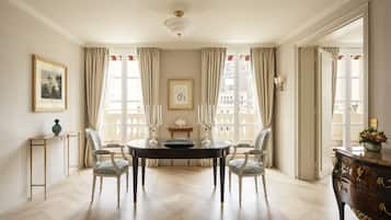 A dining room with a round table, four chairs, a vase, and a decorative console table.