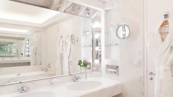 A modern bathroom with two sinks, a large mirror, and a glass shower enclosure.