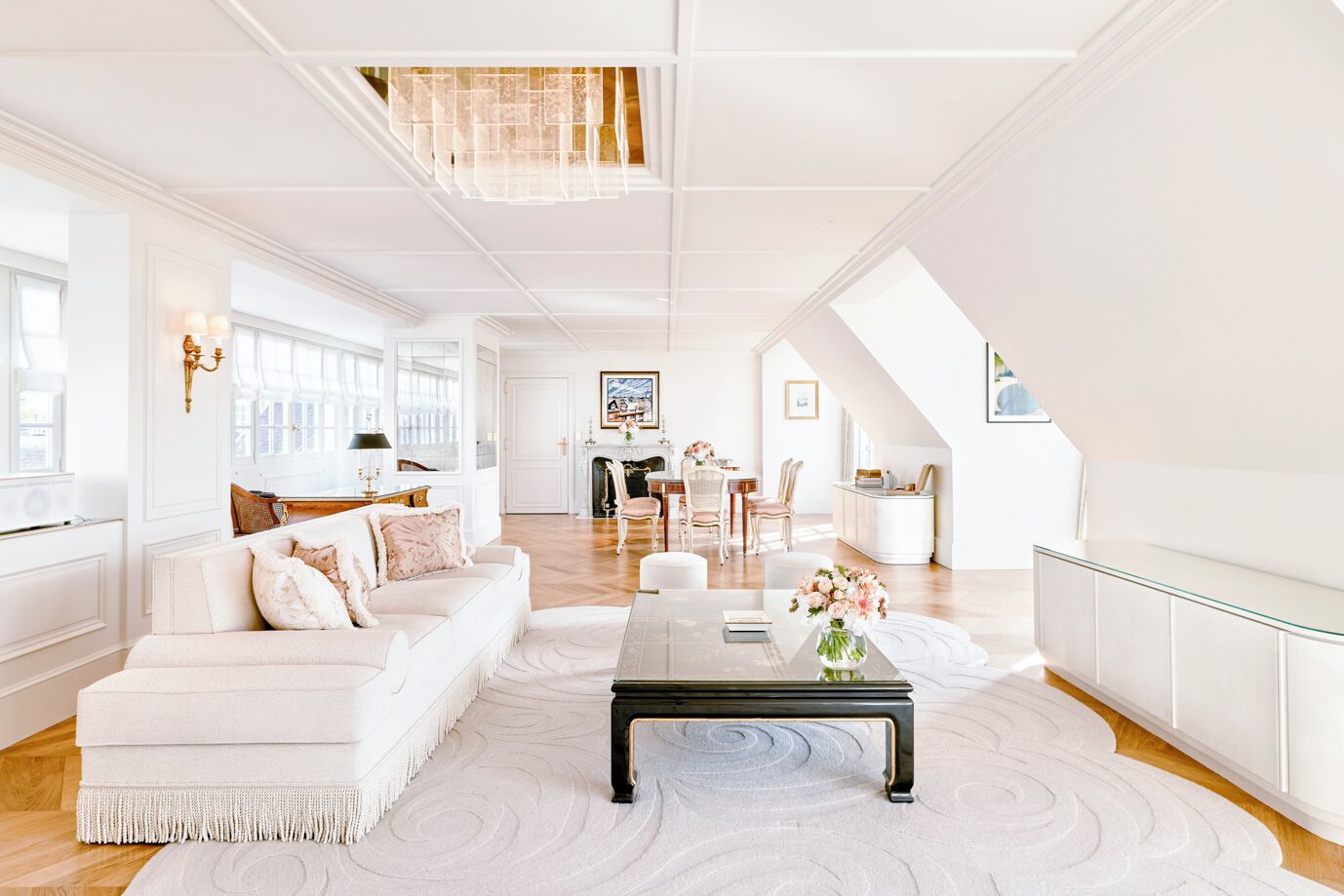 A spacious living room with a white sofa, a coffee table, and a fireplace.