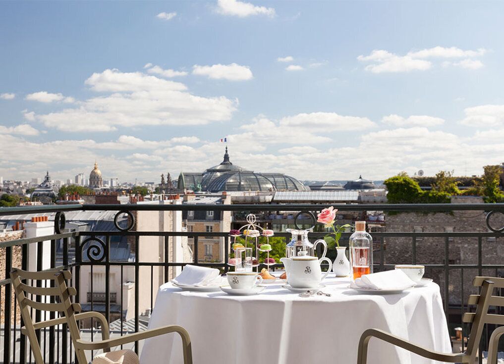 A table set for a meal with a cityscape view, including a dome and buildings in the background.