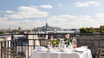 A table set for a meal with a cityscape view, including a dome and buildings in the background.