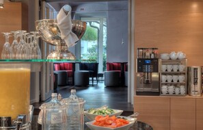 A hotel breakfast area with a buffet, a coffee machine, and seating in the background. - Holiday Inn Vienna City by IHG (Vienna)
