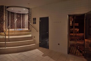 A modern hotel lobby with a spiral staircase, a reception area, and a view of the interior through a glass door.