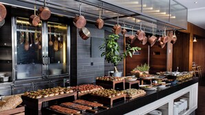 Un buffet proposant une variété de plats et agrémenté de casseroles en cuivre suspendues.