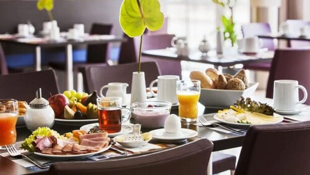 A breakfast setting with a variety of food items, including fruits, pastries, and beverages. - IntercityHotel Rostock (Rostock)