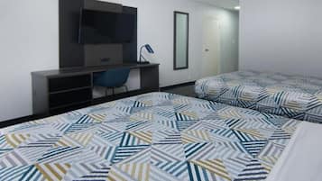 Une chambre d’hôtel avec un lit, un bureau, une chaise, une télévision et un miroir.