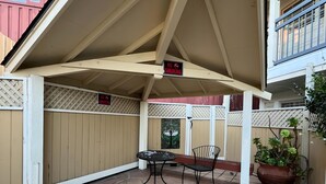 A covered patio area with a table and chairs, a potted plant, and a 'No Smoking' sign. - Inn By the Bay Monterey (Monterey)