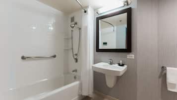 A modern bathroom with a bathtub, shower, and sink.