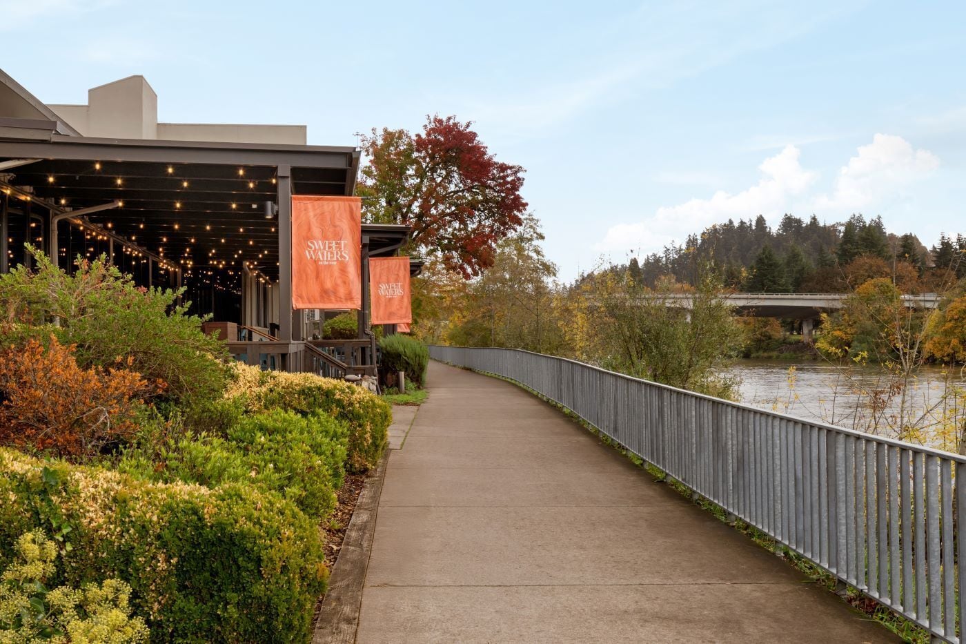 A pathway leading to a building with banners reading "Sweet Waters."