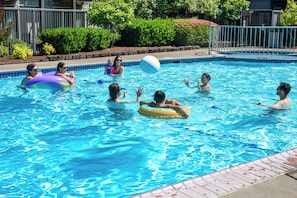 A swimming pool with people using inflatable rings.
