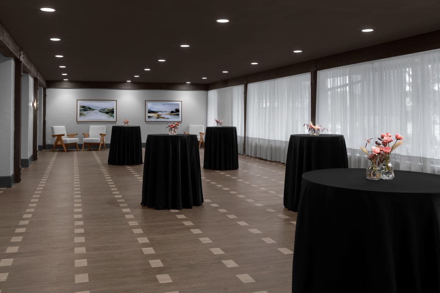 A conference room with multiple tables, chairs, and artwork on the walls.