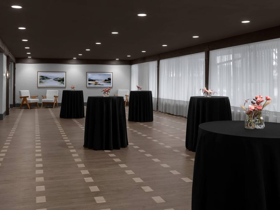 A conference room with multiple tables, chairs, and artwork on the walls.