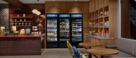 Um interior moderno com área de bar, assentos e uma variedade de petiscos e bebidas.
