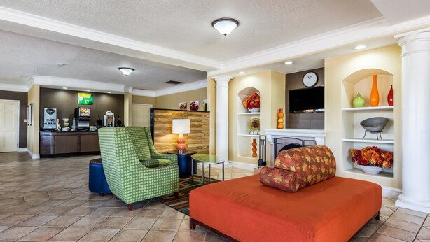 A hotel lobby with a sofa, armchair, and a fireplace.