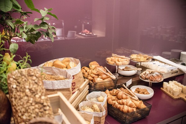 A buffet with various baked goods and pastries.