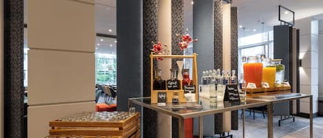 Un espace bar moderne doté d’une vitrine, de bouteilles et d’un distributeur de jus.