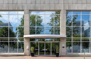 A modern building with large glass windows and a curved entrance canopy.