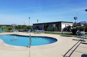 Una piscina al aire libre de temporada, sombrillas