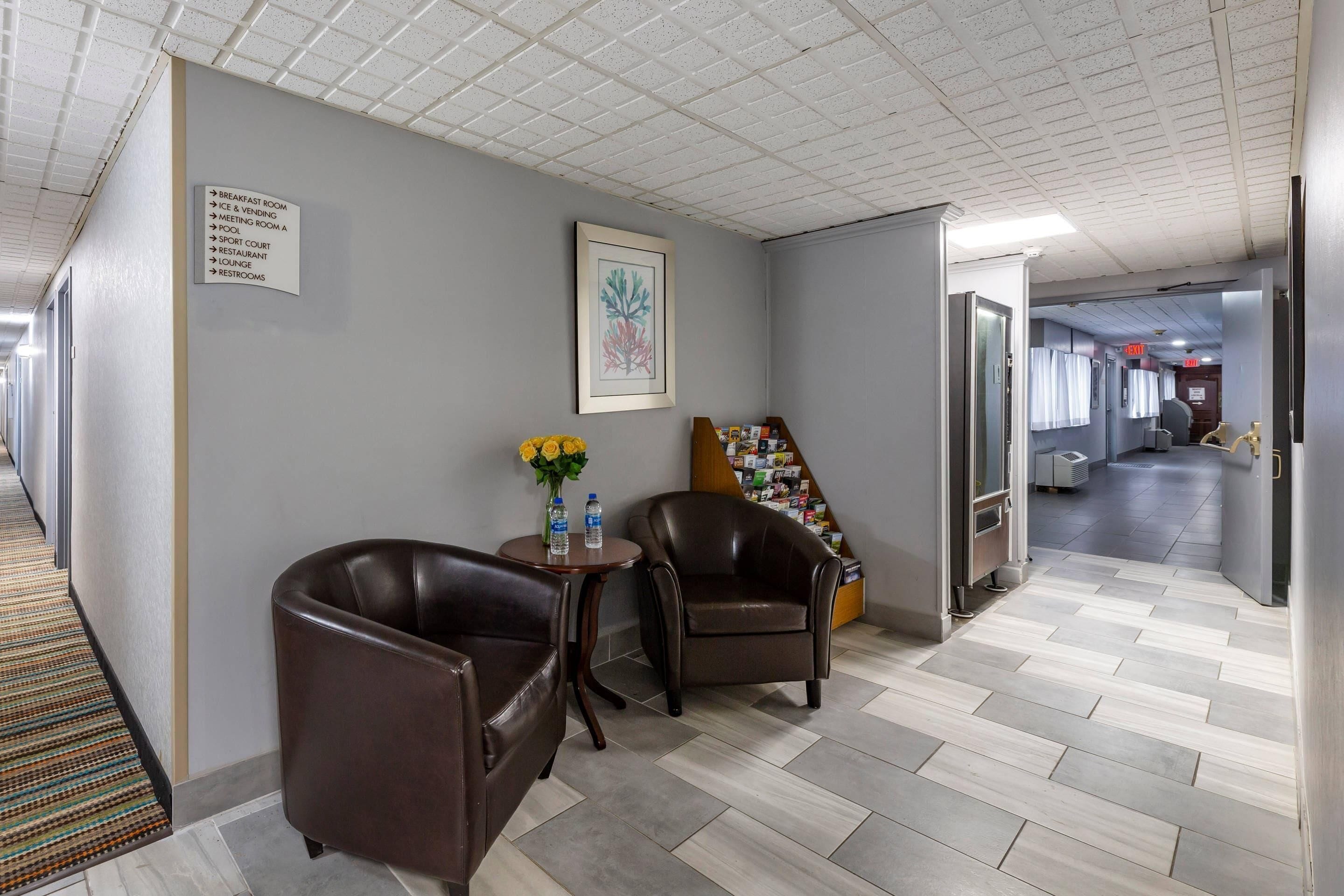 Ein Hotelkorridor mit einem Schild, das Einrichtungen wie einen Frühstücksraum, einen Eisfüllautomaten, einen Konferenzraum, einen Pool, einen Sportplatz, ein Restaurant, eine Lounge und Toiletten anzeigt.