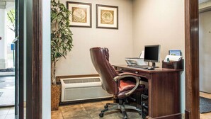 A reception area with a desk, computer, and framed artwork on the wall. - Quality Inn Austintown - Youngstown West (Austintown)