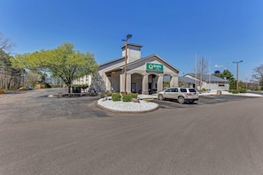 A Quality Inn by Choice Hotel with a parking lot and a white car parked in front. - Quality Inn Austintown - Youngstown West (Austintown)