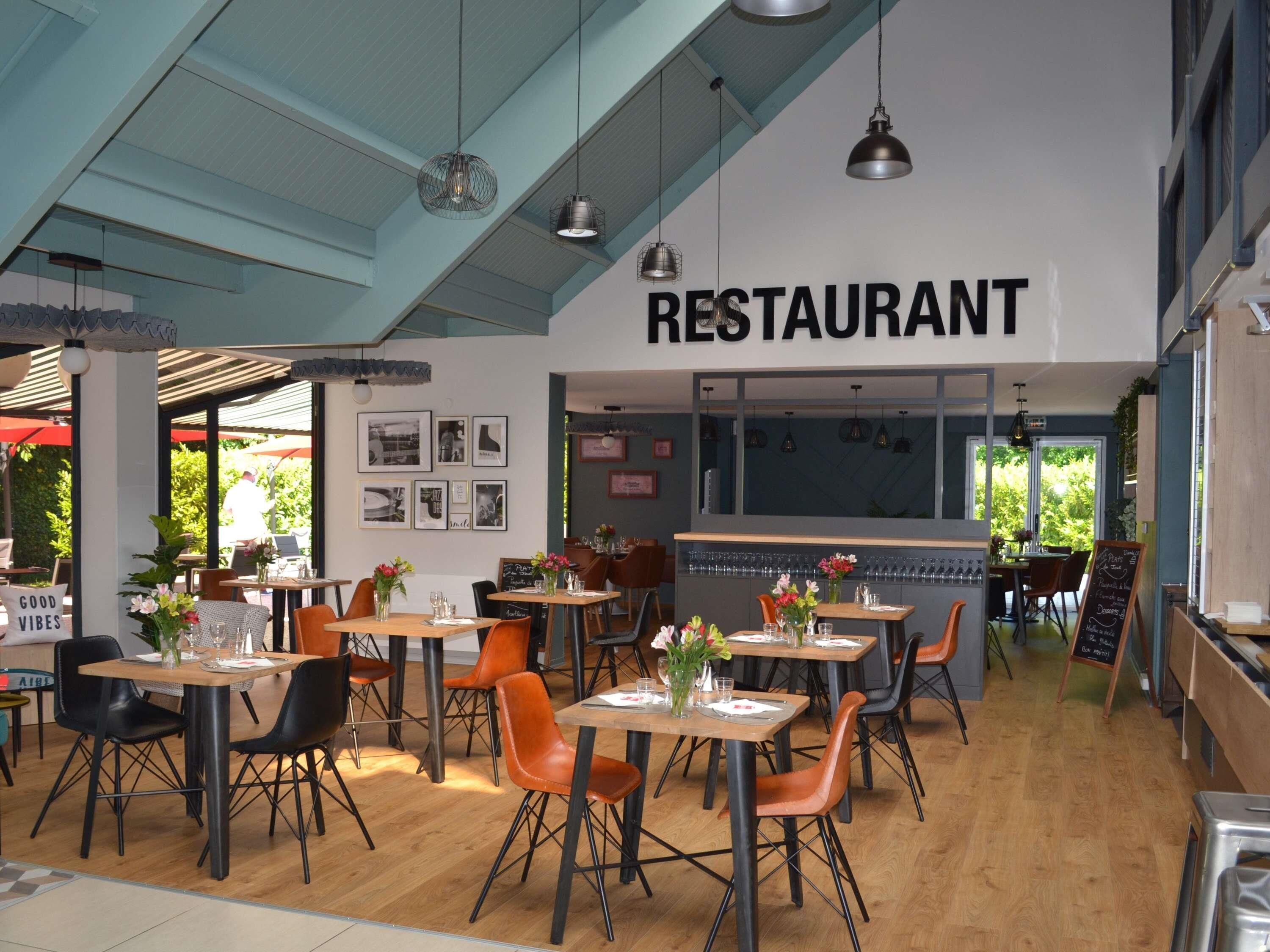 A restaurant interior with tables, chairs, and a sign that reads 'RESTAURANT'.