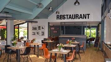 A restaurant interior with tables, chairs, and a sign that reads 'RESTAURANT'.