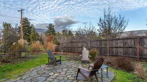 A patio with stone flooring, wooden chairs, and a wooden fence in the background. - Best Western Windsor Inn (Ashland)