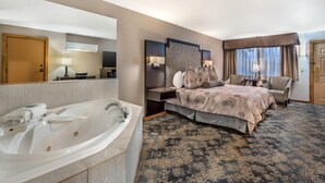 A hotel room with a large bed, a separate sitting area, a large bathtub, and a flat-screen TV. - Best Western Windsor Inn (Ashland)