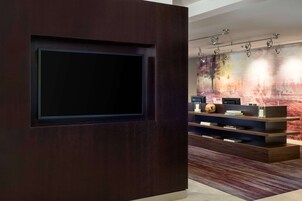 Una sala de estar moderna con un televisor de pantalla plana grande montado en una pared de madera oscura.