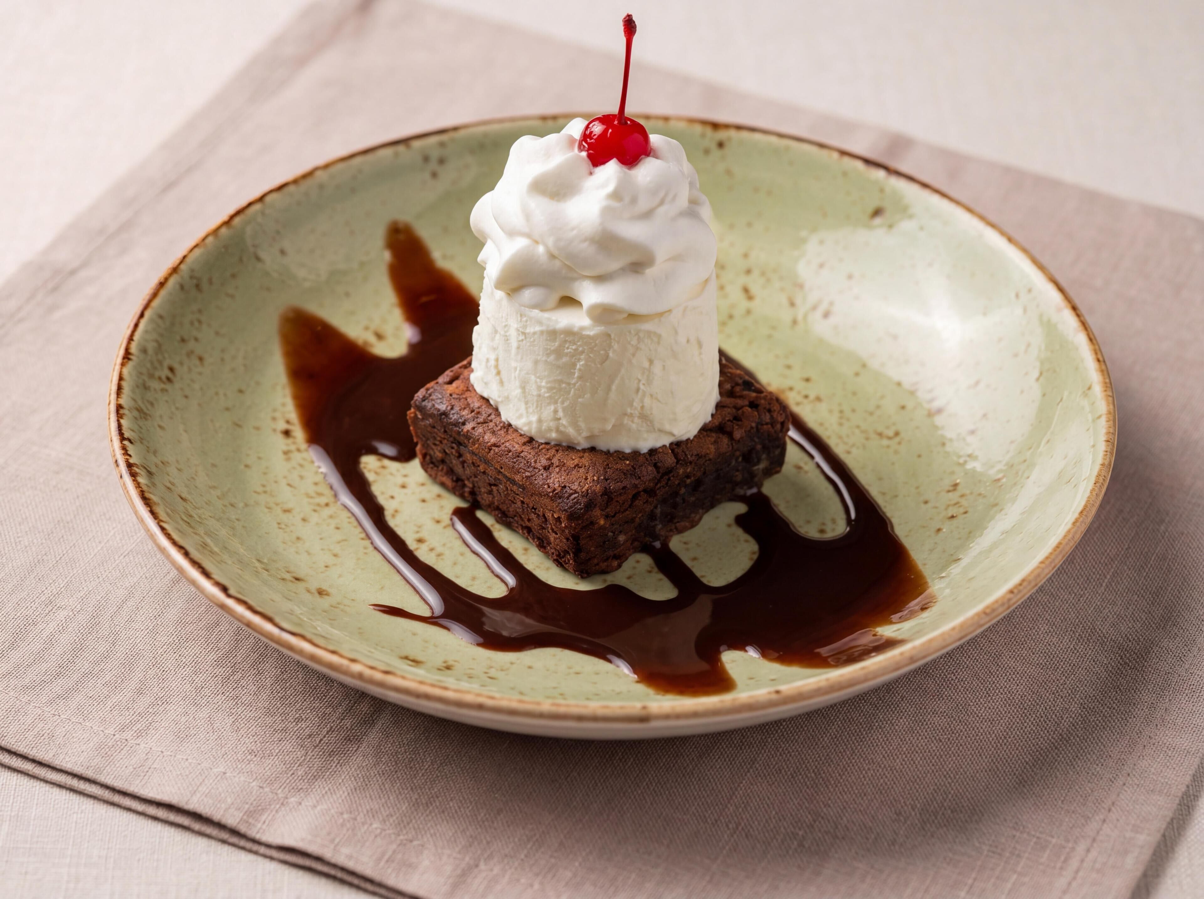 A dessert on a plate with a cherry on top.